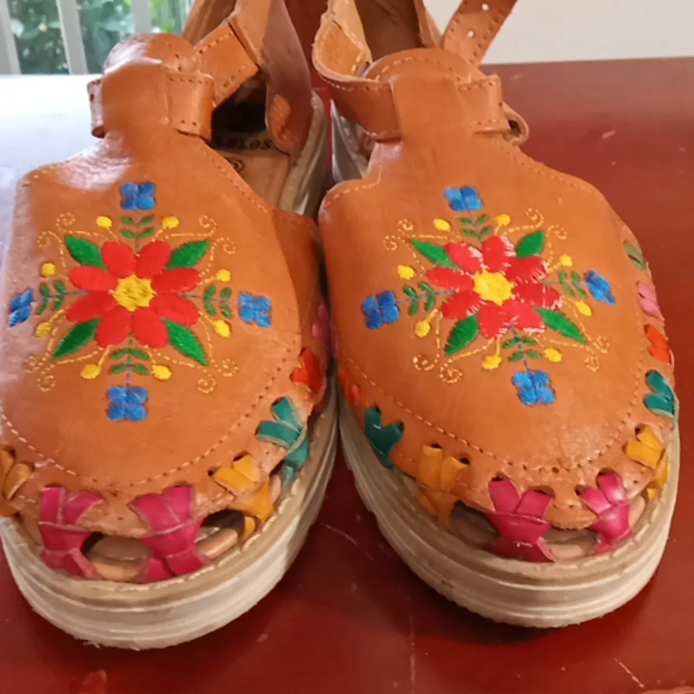 D'Lolos  Hand crafted leather sandals with embroidered floral motif.